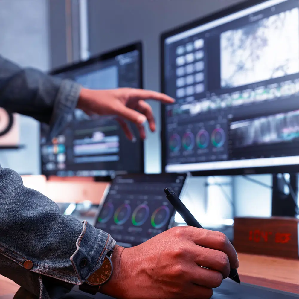 Person with pen in hand pointing to data filled computer screen.