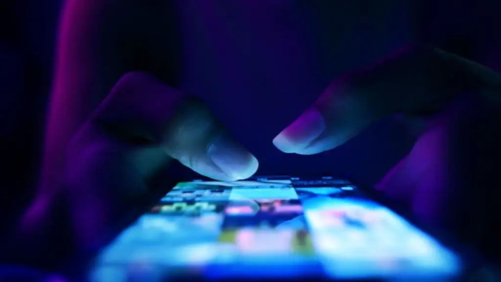 Top view of thumbs tapping on phone screen.