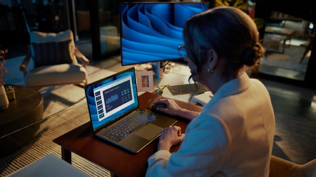 Person working from home using their laptop and viewing a weekly sales report.