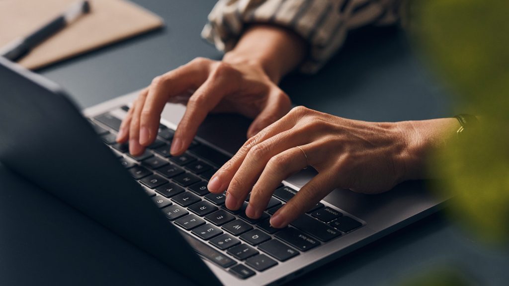 Person typing on laptop.